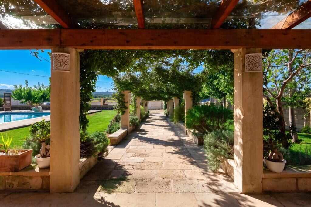 Stone pathway under the pergola beside the garden